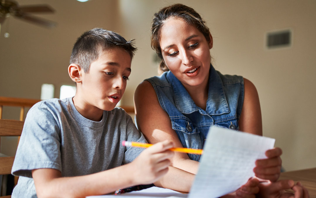woman working with child on homework